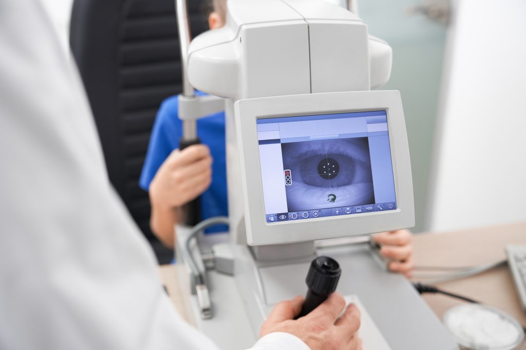 Clever male oculist using machine for checking eye sight