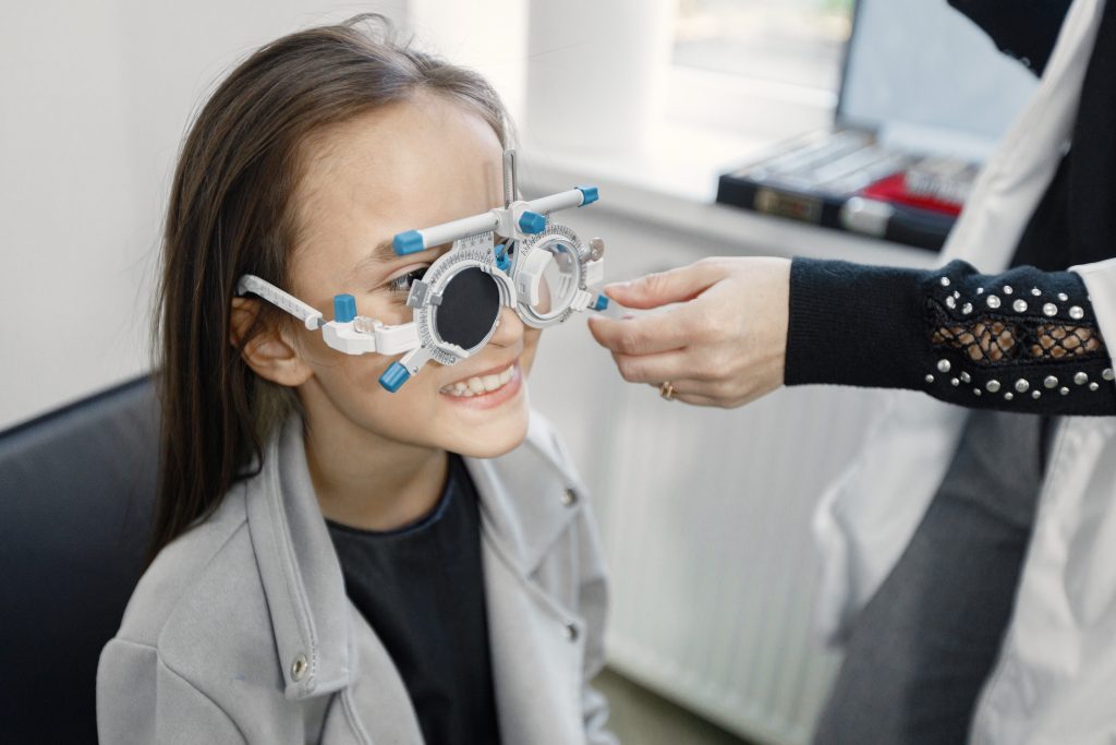 Girl doing eye test checking examination with optometrist