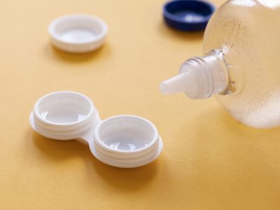 bottle-with-lens-solution-lens-box-orange-background Is it Safe to Wear Contact Lenses Every Day?